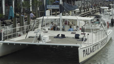 People-Relaxing-on-Docked-Catamaran-Boat-in-Shem-Creek,-SC,-Static