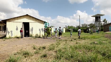 School-children-carry-chairs-to-another-building-on-the-campus-of-their-private-school-near-Nairobi,-Kenya