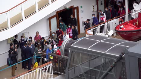 Passengers-queue-up-to-finally-disembark-from-the-World-Dream-cruise-ship-at-the-Kai-Tak-cruise-terminal-in-Hong-Kong