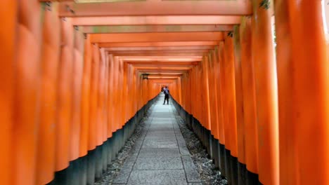 Couple-taking-photos-at-Torii-gates-in-Fushimi-Inari,-Kyoto,-Japan