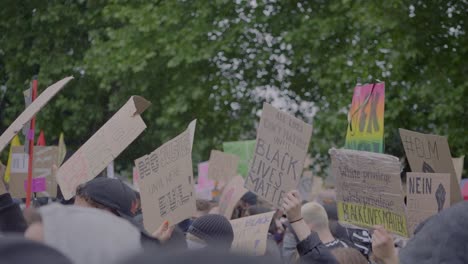 Riesige-Menschenmenge-Von-Demonstranten-Protestiert-Und-Hält-Schilder-Gegen-Rassismus-Hoch,-Während-Sie-Bei-Einem-Black-Lives-Matter-Protest-In-Einem-Park-In-Stuttgart,-Deutschland,-Jubelt.