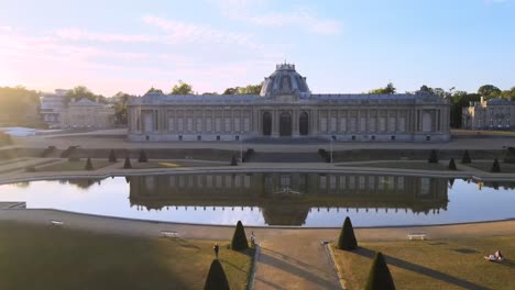 Amazing-country-estate-palace,-aerial-view-over-entrance-and-garden-at-sunset