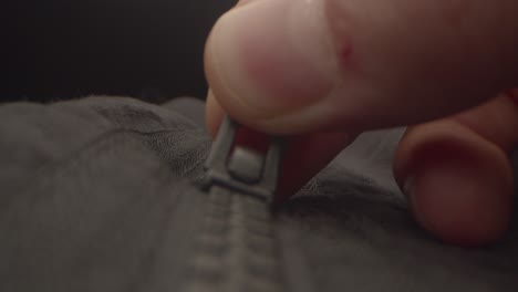 Close-up-of-a-hand-closing-a-zipper-on-a-black-coat