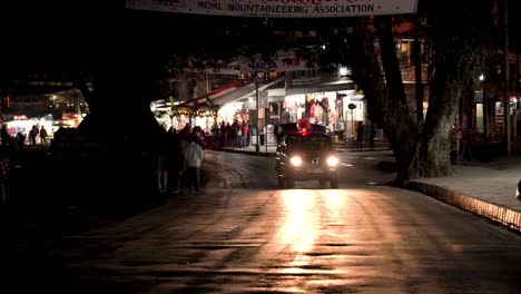 Local-police-van-passing-by-the-street-in-the-evening-at-Lakeside,-Pokhara,-Nepal