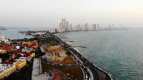 Aerial,-tracking,-drone-shot-of-the-Cartagena,hotels,-resorts-and-traffic-on-the-Avenida-Santader-road,-during-sunset,-in-Colombia