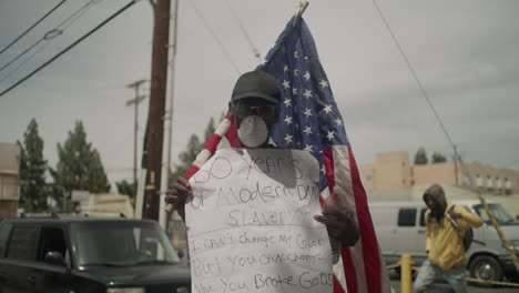 Protestor-holding-up-a-sign-during-a-protest-by-City-Hall-during-the-day