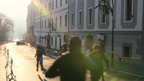 Corredores-Que-Compiten-En-Una-Carrera-De-Maratón-Benéfica-Al-Amanecer-Con-Destellos-De-Lente,-Eslovaquia