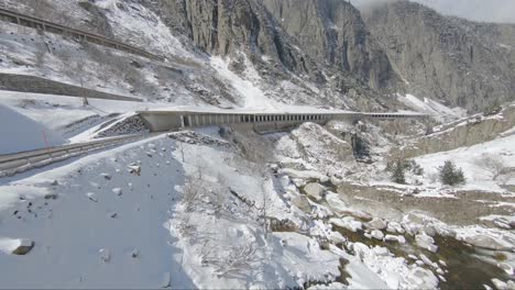 Ferrari-tackling-steep-corners-on-a-mountain-road-surrounded-by-snow