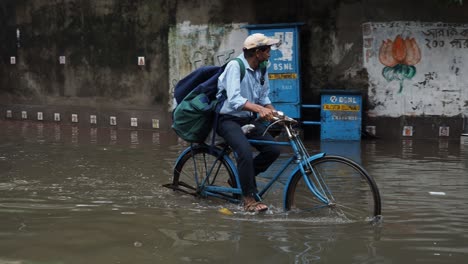 Poor-courier-delivery-on-a-cycle-in-rainy-weather-in-Kolkata,-India