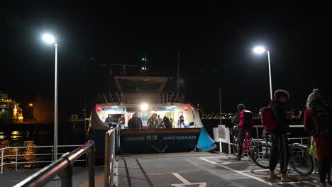 Pasajeros-Que-Desembarcan-En-Ferry-Por-La-Noche-En-Amsterdam,-Países-Bajos