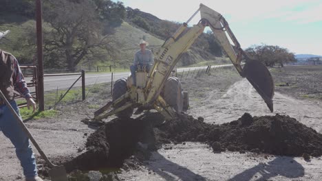 Tractor-Retroexcavadora-Limpiando-Una-Fuga-De-Agua.