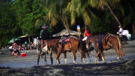 People-riding-horses-at-a-tropical-beach-in-Costa-Rica-during-golden-hours-as-a-travel-destination-and-vacation