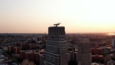 Aerial-view-away-from-the-Claremont-Hall-high-rise,-sunset-in-NYC,-USA---pull-back,-tilt,-drone-shot