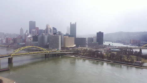 Drone-pan-reveal-shot-of-downtown-Pittsburgh-with-snow-falling