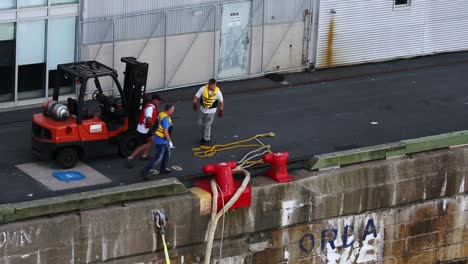 Dock-workers-using-forklift-to-cast-off-large-mooring-lines-of-cruise-ship-in-Halifax