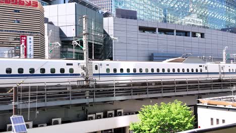 A-JR-Central-Tokaido-Shinkansen-train-departs-Tokyo-Station-passing-by-Yurakucho-on-its-way-to-Shin-Osaka,-ferrying-commuters-along-the-high-speed-rail-network