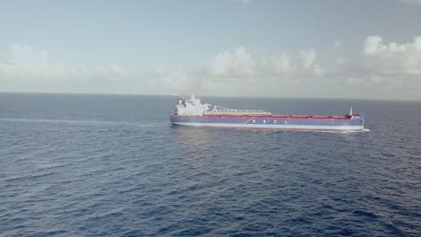 AERIAL---Huge-cargo-ship-in-the-ocean-at-dawn-near-Cancun,-Mexico,-spinning-shot