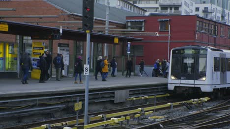 Oslo-tramway-train-entering-terminal,-with-pedestrians-and-passengers-in-Majorstuen