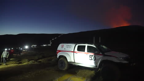 Parking-Icelandic-Emergency-Rescue-Car-beside-group-of-tourists-walking-back-after-visiting-Geldingadalir-Volcano-Eruption-at-night-in-Iceland