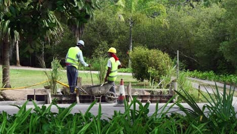 Two-Indian-workers-doing-pedestrian-pavement-near-the-road-on-Mahe-island