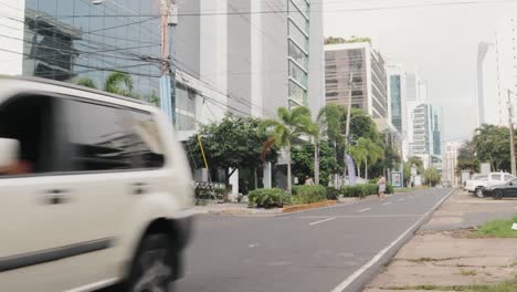 Pan-shot-of-a-traffic-intersection-revealing-the-modern-cityscape-of-Panama,-showcasing-the-investment-into-the-urban-real-estate-development-of-the-city