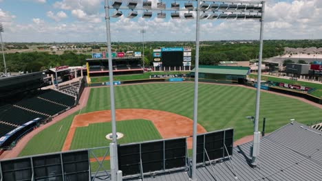 Round-Rock-Express-Dell-Diamond-Baseball-Stadium-aerial-drone-pull-away-through-lights-on-sunny-summer-Texas-day-in-4k