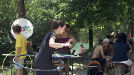 Mujer-Joven-Hula-hooping-En-La-Playa-En-El-Festival,-Día-Soleado-De-Verano,-Cámara-Lenta