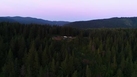 Flug-Bergauf-Zu-Einem-Unbebauten-Campingplatz-Mit-Einer-Gruppe,-Die-Sich-Um-Ein-Lagerfeuer-Versammelt-Hat