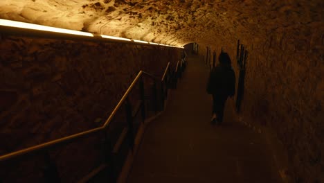 Young-woman-going-down-the-staircase-inside-an-ancient-building