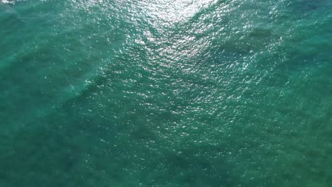 Cristal-clear-blue-atlantic-ocean-water-and-a-pier-aerial-view-in-Cadiz,-Spain