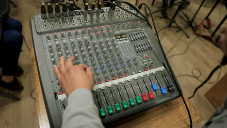 Ein-Mann,-Der-Die-Mikrofonlautstärke-Mit-Einem-Audiomixer-In-Einem-Studio-Einstellt