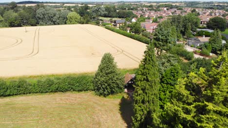 Aerial-of-Needham-market,-drone-fly-above-christian-cemetery-and-plowed-field