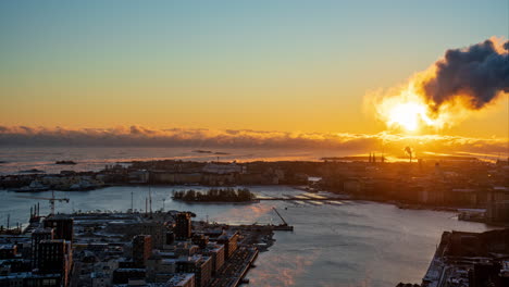 Lapso-De-Tiempo-Del-Mar-Humeante-Detrás-De-La-Ciudad-De-Helsinki,-Puesta-De-Sol-De-Invierno-En-Finlandia