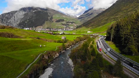 Antenne:-Tal,-Roter-Zug-Und-Straße-In-Den-Schweizer-Alpen