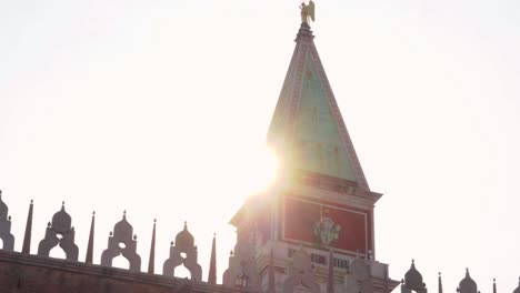 Venice---St-Mark's-Campanile-with-sun-flare,-disappearing-behind-wall---parallax-gimbal-shot