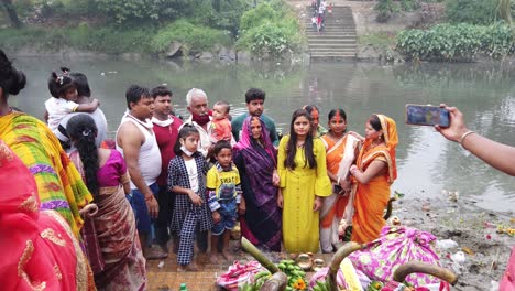 View-of-the-Indian-people-doing-rituals-during-Hindu-wedding-with-fruits,-fire,-flowers-standing-in-front-of-ganga-river-water