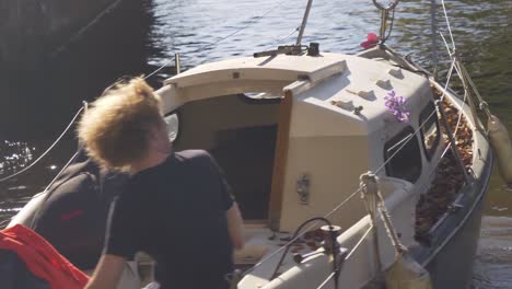 The-young-man-is-driving-an-old-sport-boat-on-the-channel-in-the-Amsterdam-city-center