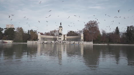 Birds-flying-above-Buen-Retiro-park-lake-monument-Madrid