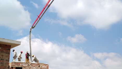 Un-Equipo-De-Constructores-Africanos-Vertiendo-Cemento-Desde-El-Brazo-De-Un-Camión-Bomba-De-Hormigón-Hidráulico,-Los-Hombres-Construyen-El-Techo-De-Una-Nueva-Casa-Residencial,-Sudáfrica