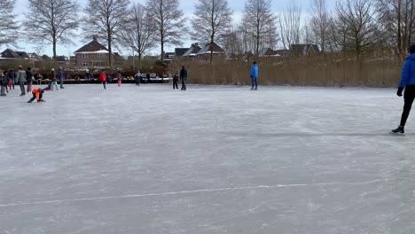 La-Gente-Disfruta-Patinando-Sobre-Hielo,-Andando-En-Trineo-Y-Caminando-Sobre-Hielo-En-Un-Estanque-Helado-En-Un-Parque-De-La-Ciudad-Durante-El-Frío-Helado-De-Febrero,-Que-Duró-Solo-Una-Semana.