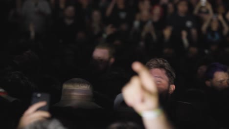 Campo-De-Conciertos-Lleno-De-Gente-Con-Público-Saltando-Al-Ritmo-De-La-Música-Por-La-Noche