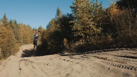 Female-motocross-rider-jumping-in-slow-motion-and-lands-in-front-of-the-camera