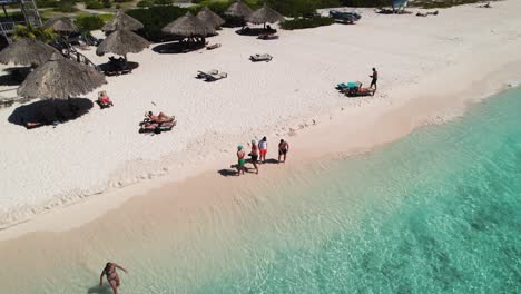 Grupo-De-Amigos-Volando-Drones-En-Una-Playa-Tropical-De-Aguas-Turquesas