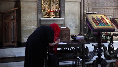 Women-In-Red-Head-Covering-Writing-At-Table-Inside-Sioni-Cathedral