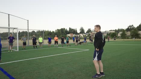 Große-Gruppe-Von-Männern,-Die-In-Den-Frühen-Morgenstunden-Freizeitaktivitäten-Auf-Einem-Fußballfeld-Nachgehen