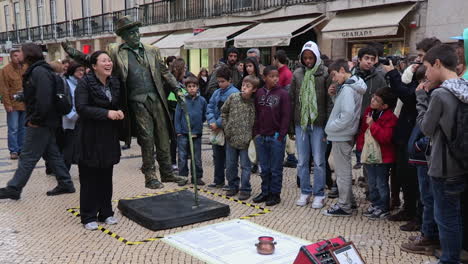 Amazing-people-on-Rua-Augusta,-seeing-the-levitation-of-the-living-statue-man,-a-cheerful-tourist-takes-a-picture-with-him