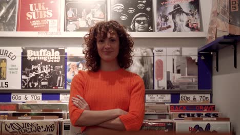 Joyful-Curly-Hipster-Woman-Among-Vinyl-Records-Shelves-In-Music-Store