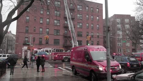 Neugierige-Passanten-Beobachten-Feuerwehrmann,-Der-Während-Eines-Schneesturms-Bei-Einem-Brand-Auf-Dem-Dach-Eines-Gebäudes-In-Brooklyn-Hilft-–-Weitwinkelaufnahme