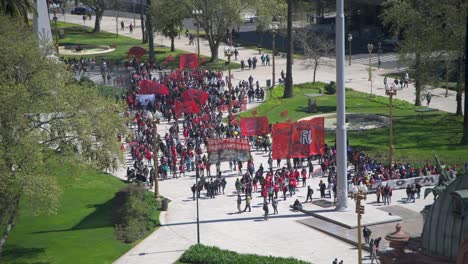 Protesting-against-government-people-are-walking-down-the-street-in-Buenos-Aires-holding-red-banners