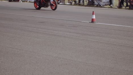 Low-angle-panning-shot-of-a-sports-bike-racing-on-an-asphalt-track